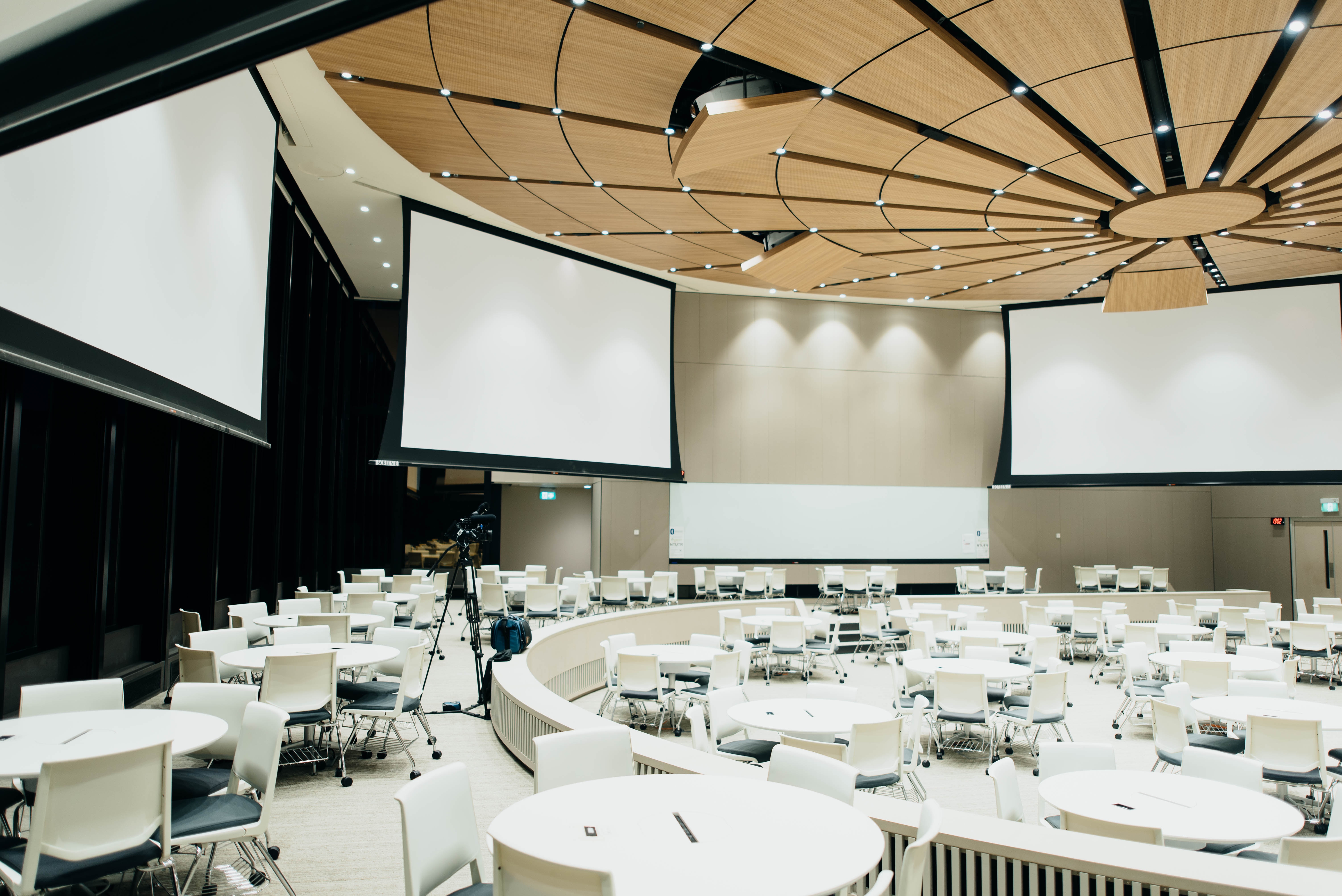 Empty conference room with white tables and presentation screens