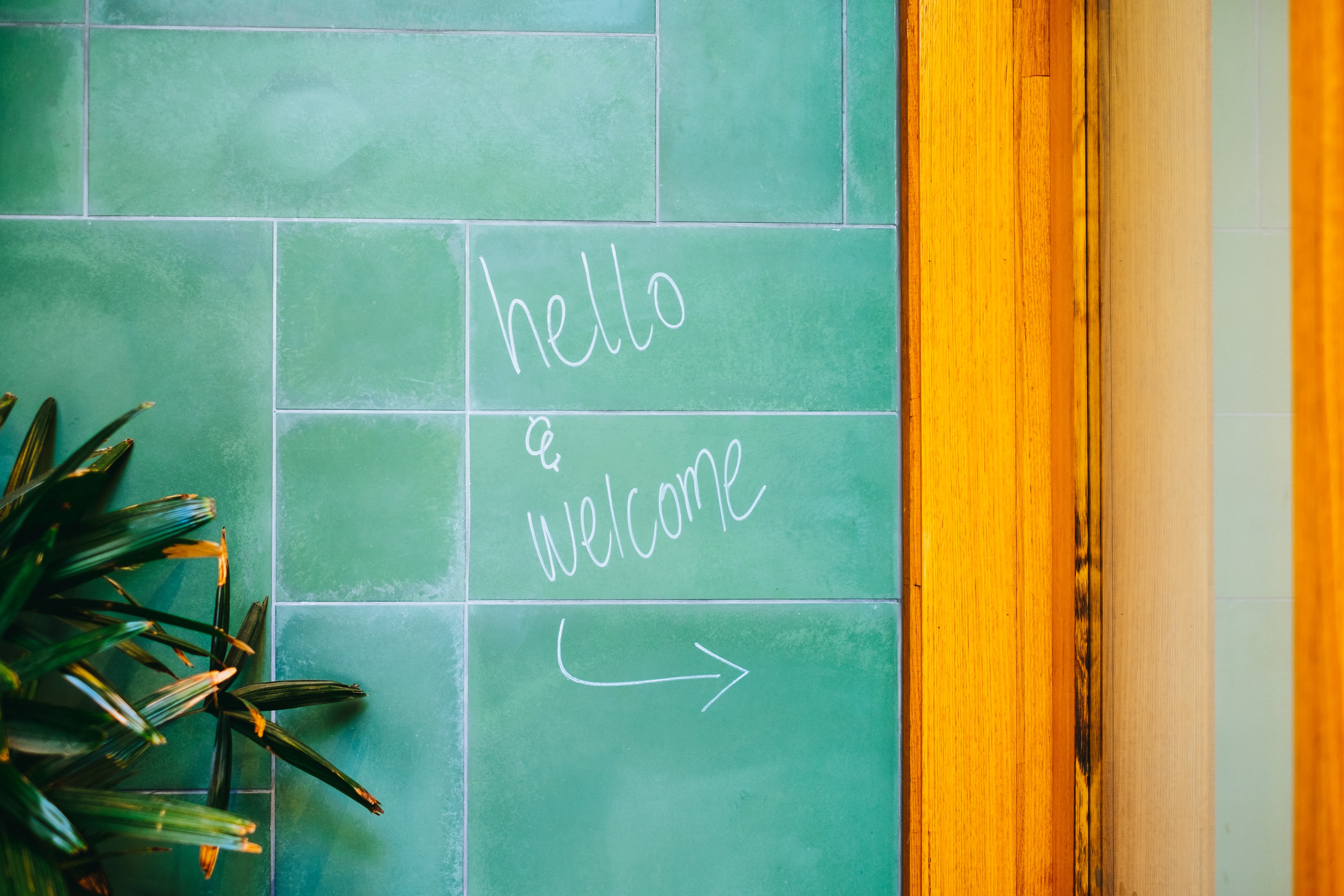 hello and welcome written on a teal wall