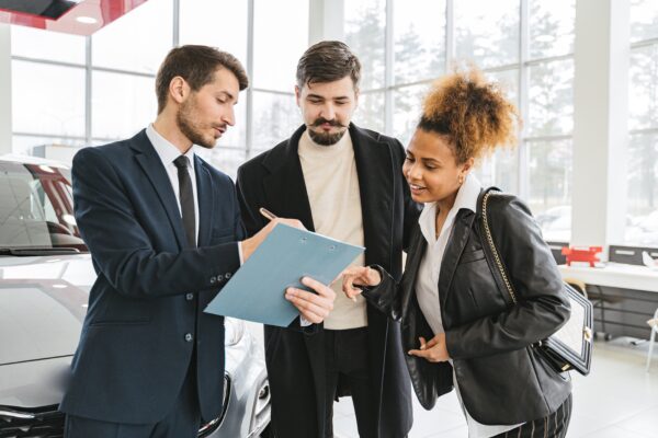 Customers reviewing a contract at a dealership