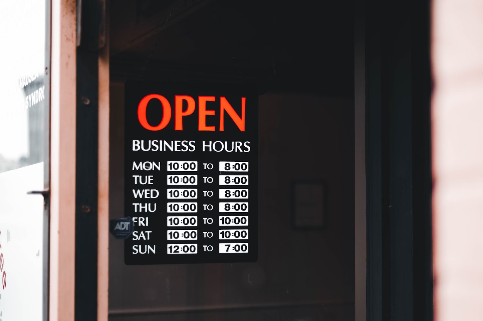 Open Sign on Business Door with Hours Listed
